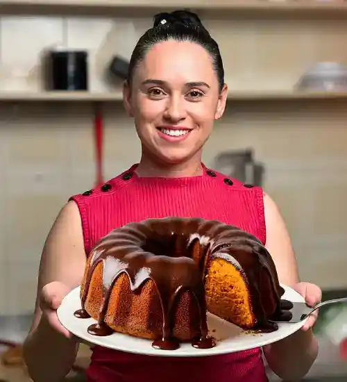 Expert Keli Gabriel segurando um bolo de cenoura com calda de chocolate