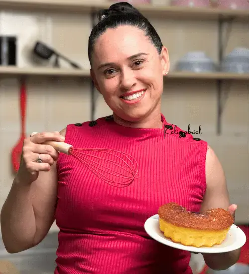 Expert Keli Gabriel segurando um bolo de fubá em uma das mãos e na outra mão, um tatedor.